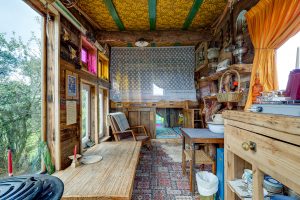 An image of the interior space in our wagon on Dalby Forest, North Yorkshire showcasing our table, seating area and also cooking facilities.