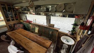 An interior image of the portmaster glamping wagon based in Dalby forest, North Yorkshire. Eating area and unique quirky design.